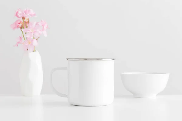 花瓶にピンクのオレンダーの花束と白いテーブルの上にボウルとエナメルマグカップモックアップ — ストック写真