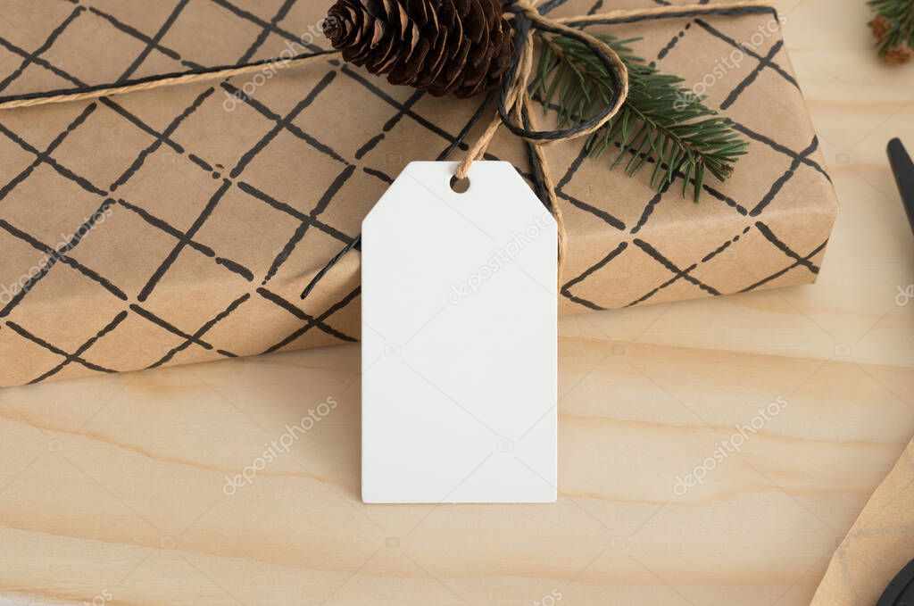 White blank tag mockup isolated on a kraft christmas gift.