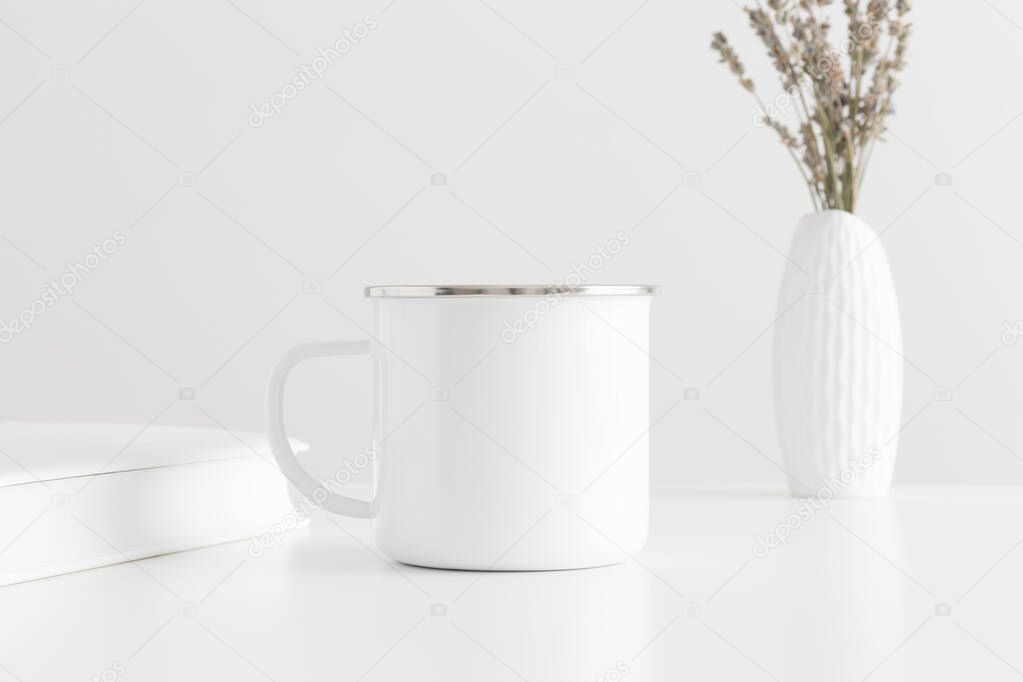 Enamel mug mockup with a lavender in a vase and a book on a white table.