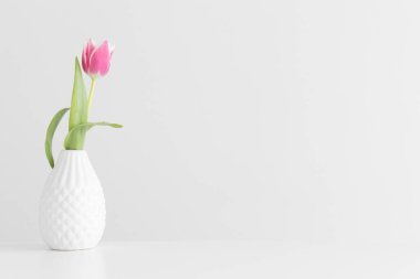 Boş kopya alanı olan beyaz bir masadaki vazoda pembe lale..