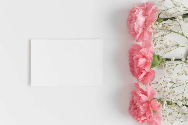 Pohled Shora Bílou Kartu Gypsophilou Růžovými Karafiáty Bílém Stole — Stock fotografie