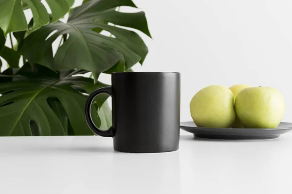 Schwarze Becher Attrappe Mit Äpfeln Auf Weißem Tisch Und Einer — Stockfoto
