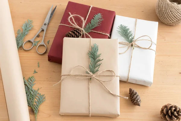 Karácsonyi Ajándékok Egy Fából Készült Asztalon Zsineggel Ollóval Csomagolópapírral — Stock Fotó