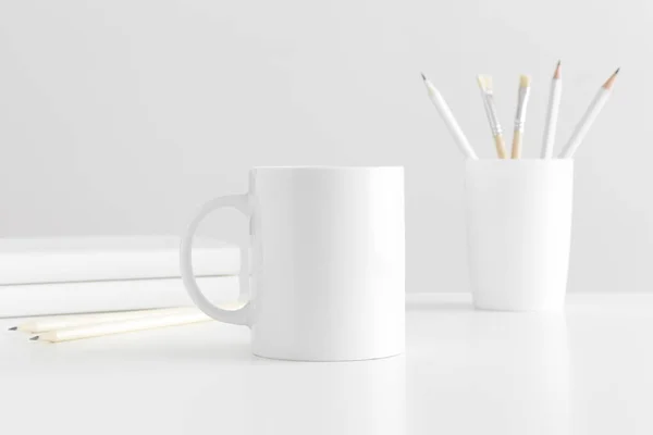 白いテーブルの上のワークスペースアクセサリーとマグカップのモックアップ — ストック写真