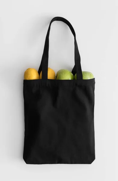 Bolsa Asas Negra Maqueta Con Fruta Una Mesa Blanca —  Fotos de Stock