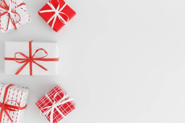 Beyaz bir masada kırmızı ve beyaz noel hediyeleri. Boş kopya alanı ile düz yatıyordu.