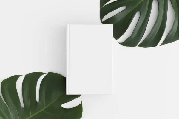 Vista Superior Una Maqueta Libro Blanco Con Decoración Hojas Monstera — Foto de Stock