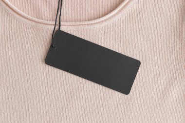 Yumuşak pembe bir kazak üzerinde siyah giysi modeli.