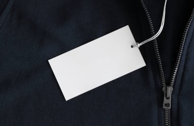 Mavi bir kazak üzerinde beyaz giysi etiketi..