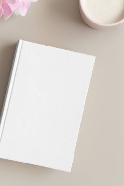 Bir fincan kahve ve bej bir masada zakkum eşliğinde beyaz kitap modeli..