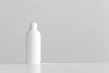 Beyaz bir masanın üzerinde boş fotokopi alanı olan beyaz bir kozmetik şişe..