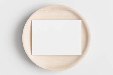 Davetiye beyaz kart maketi ahşap bir tabakta. 5x7 oranı, A6, A5 'e benziyor..