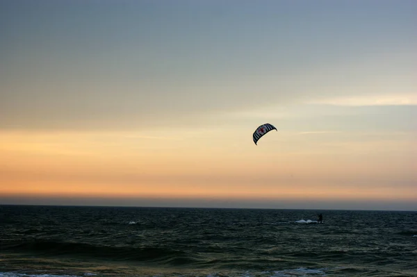 water sport kitesurfer by the sea at sunset