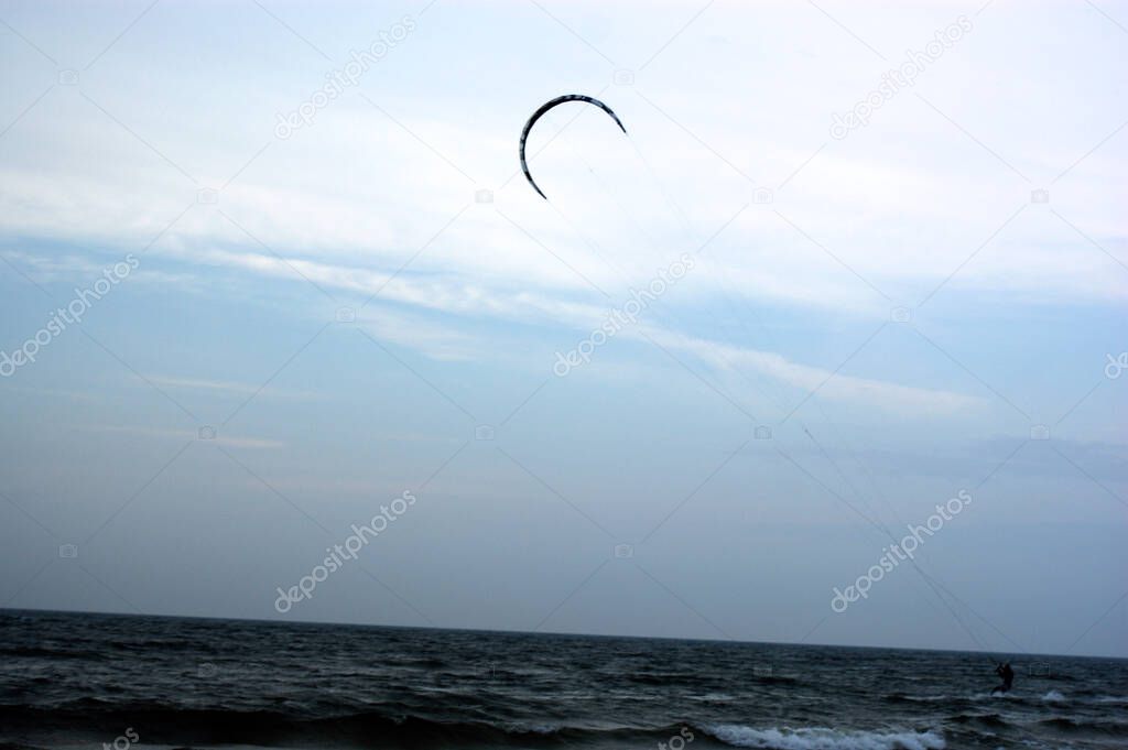 water sport kitesurfer by the sea at sunset