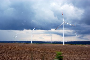 Rüzgâr çiftliği rüzgâr gülü tarlasında Bulutlu mavi gökyüzüne karşı
