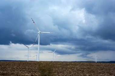 Rüzgâr çiftliği rüzgâr gülü tarlasında Bulutlu mavi gökyüzüne karşı