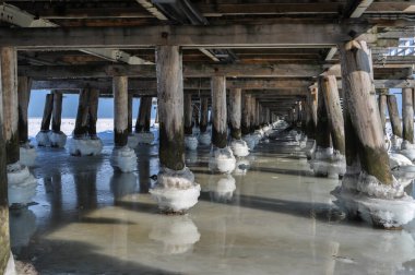 Köprünün altındaki donmuş deniz suyu. İskele topları sırayla direkler.