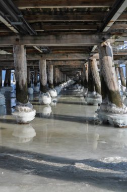 Köprünün altındaki donmuş deniz suyu. İskele topları sırayla direkler.