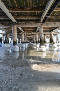 Köprünün altındaki donmuş deniz suyu. İskele topları sırayla direkler.