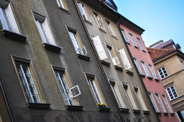 Varşova Polonya 'nın eski kasabasının arka sokağındaki renkli apartmanlar Avrupa' da beyaz pencereler geziyor