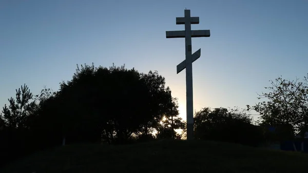 站在山上的石头东正教十字架 背景是树木的轮廓和明亮的日落天空 象征着信仰 宽恕和人民的团结 — 图库照片