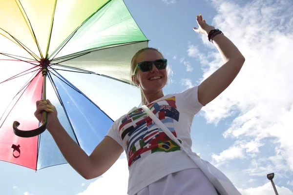 Moskova, 11 Haziran 2018, kazıklar üzerinde bir şemsiye ile bir kız Futbol Şampiyonası misafirlerle buluşuyor