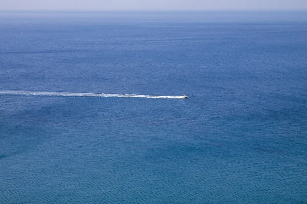 Dalgalar üzerinde mavi deniz ve tekne yarışı 