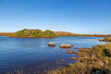 Güneşli bir yaz günü Hebridean adası Güney Uist 'te Druidbeg Gölü' ne bakıyorum.