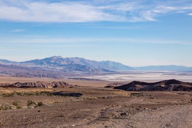 Kaliforniya, Ölüm Vadisi 'ne bakıyorum. Tuzlu düzlükler ve engebeli dağlarla mavi gökyüzünün altında.