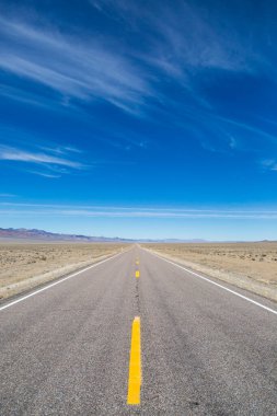 Nevada 'daki dünya dışı otoyola bakıyorum. Mavi bir gökyüzü ve ince bulutlarla.