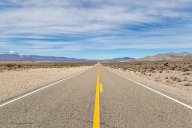 Nevada çölü boyunca uzanan uzun, düz dünya dışı yola bakıyorum.