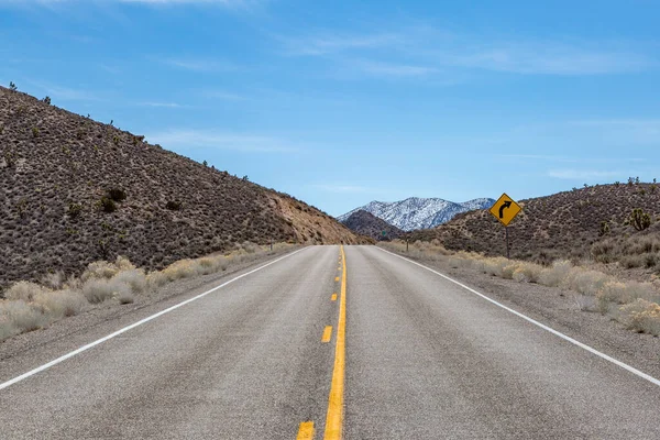 Guardando Giù Una Strada Nevada Con Una Montagna Innevata Lontananza — Foto Stock