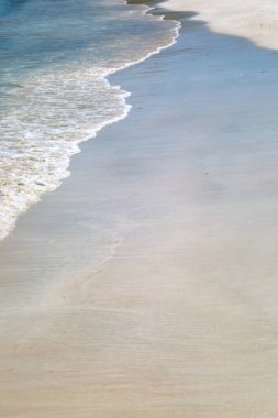 Antigua 'nın Karayipler adasında kumlu bir sahilde dalgalar.