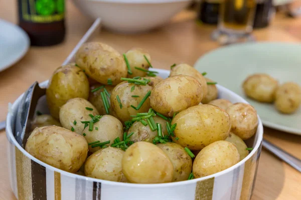 A bowl of new potatoes in a bowl, on an outdoor dining table