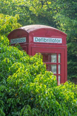 Oxfordshire köyünde içinde defibrilatör bulunan dönüştürülmüş kırmızı bir telefon kutusu.