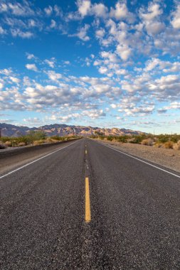 Kaliforniya çölünde Joshua Tree Ulusal Parkı 'nın yanında uzun, düz bir yol.