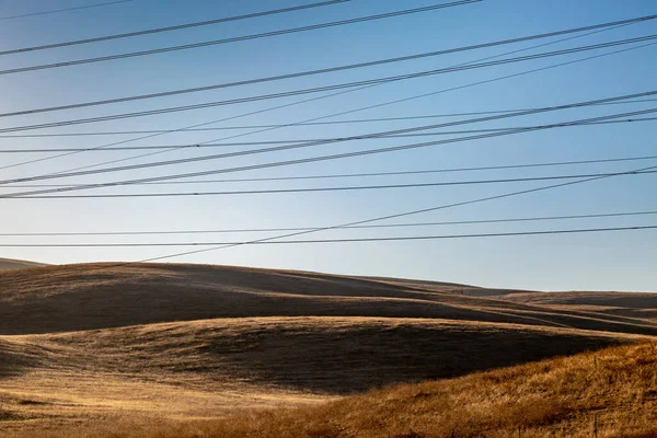 Kable Zasilające Przed Czystym Niebem Przechodzące Przez Suchy Kalifornijski Krajobraz — Zdjęcie stockowe