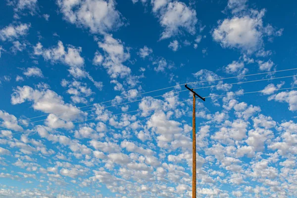 Patrząc Kable Zasilające Przeciwko Błękitnemu Niebu Puszystymi Białymi Chmurami — Zdjęcie stockowe