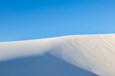 Beyaz alçıtaşı kumu Beyaz Kumlar Ulusal Anıtı 'nda, açık mavi gökyüzü ile
