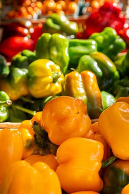 Çiftçi pazarında satılık çeşitli renkli dolma biberler, sığ bir tarla derinliği var.