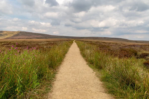 Derbyshire 'da Pennine Yolu boyunca uzanan boş bir yola bakıyorum, başımın üstünde bulutlu bir gökyüzü