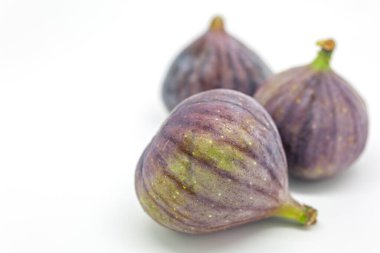 Beyaz arkaplana karşı incir, sığ bir alan derinliği var.