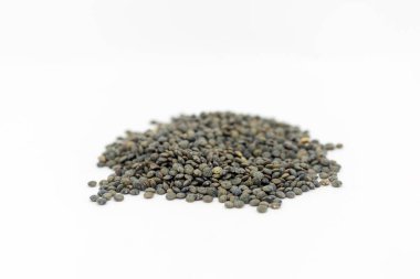 Beyaz arka planda, sığ bir alan derinliğinde kurumuş puf mercimek yığını.