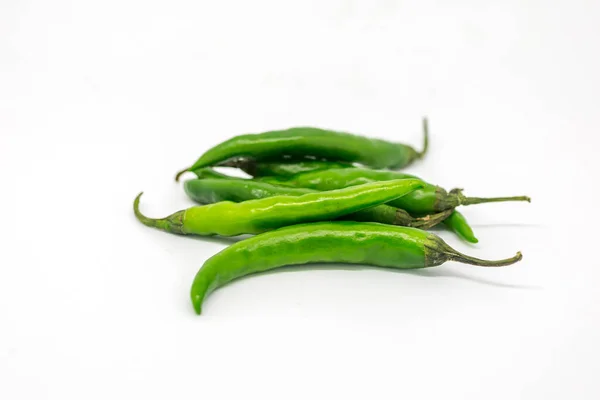 Green Chillies against a white background, with a shallow depth of field