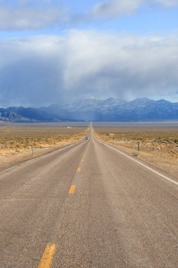 Nevada 'nın ücra bir köşesinde uzun ve düz bir yolun fotoğrafı..