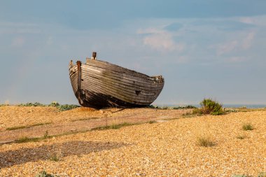 Kent 'teki çakıl taşı sahilinde eski bir balıkçı teknesi.