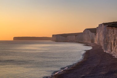 Sussex kıyısındaki Beachy Head yakınlarındaki tebeşir kayalıkları, gün batımında.