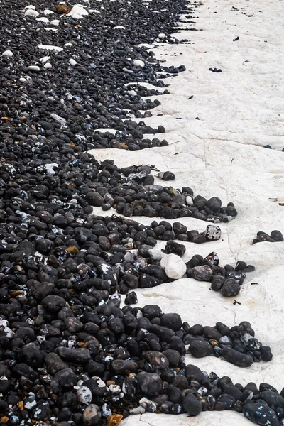 Uma Fotografia Quadro Inteiro Pedras Pretas Contrastantes Contra Rocha Branca — Fotografia de Stock