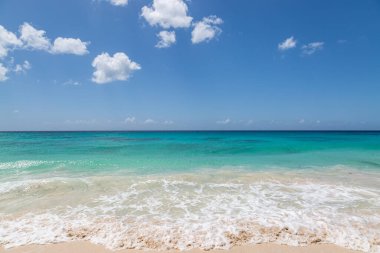 Üzerinde mavi gökyüzü olan turkuaz bir okyanusa bakıyorum, Karayipler 'deki Barbados adasında.