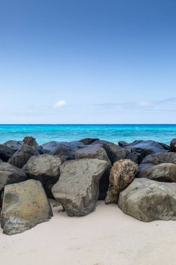 Karayipler 'deki Barbados adasındaki büyük kayalardan oluşan bir bariyerin üzerinden denize bakıyorum.